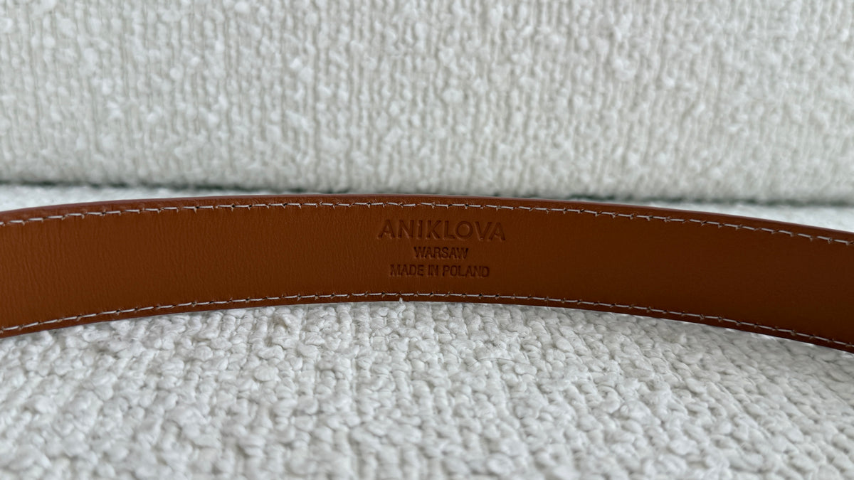 Pasek ze skóry NAPPA detal tłoczonego logo ANIKLOVA damski skórzany pasek koniakowy